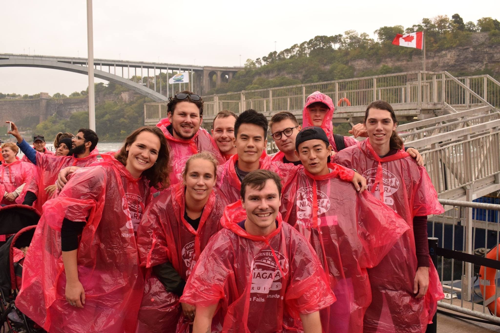 A group people posing with their transparent red rain coats.